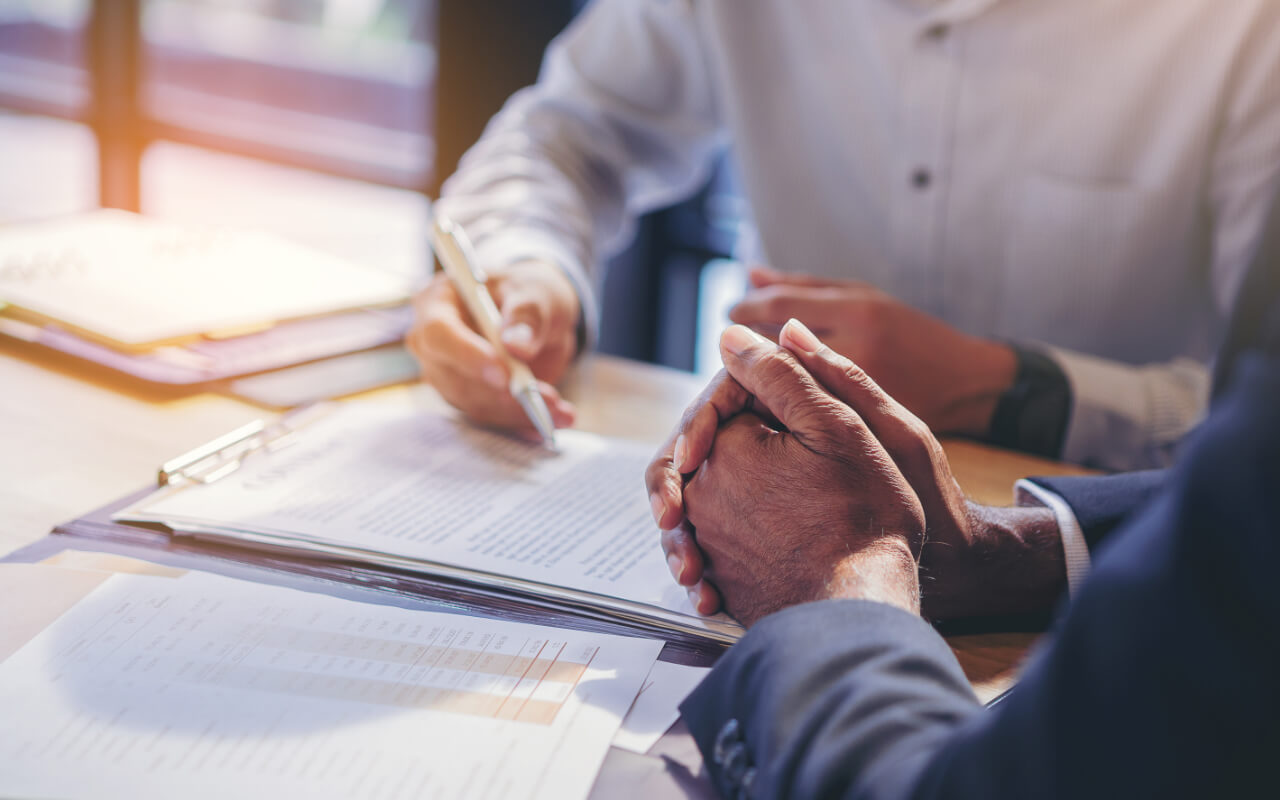 two men in business clothes go through contract together 