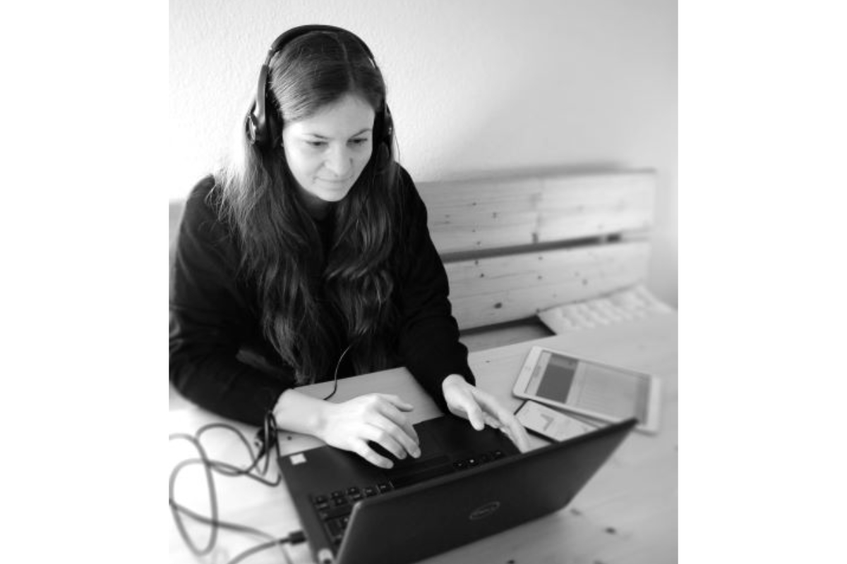 Magdalena Klimm doing work on her laptop using her headset