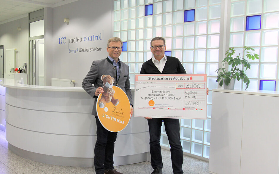 Robert Pfatischer (meteocontrol) presents the donation to Mr. Thomas Kleist (LICHTBLICKE e.V.)